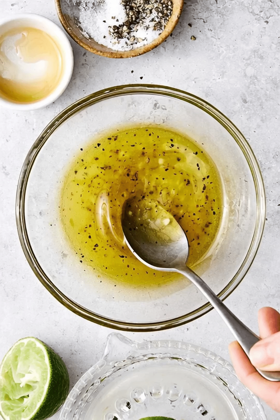 Homemade Honey Lime Salad Dressing Prep Honey lime salad dressing with olive oil black pepper and garlic in a glass bowl