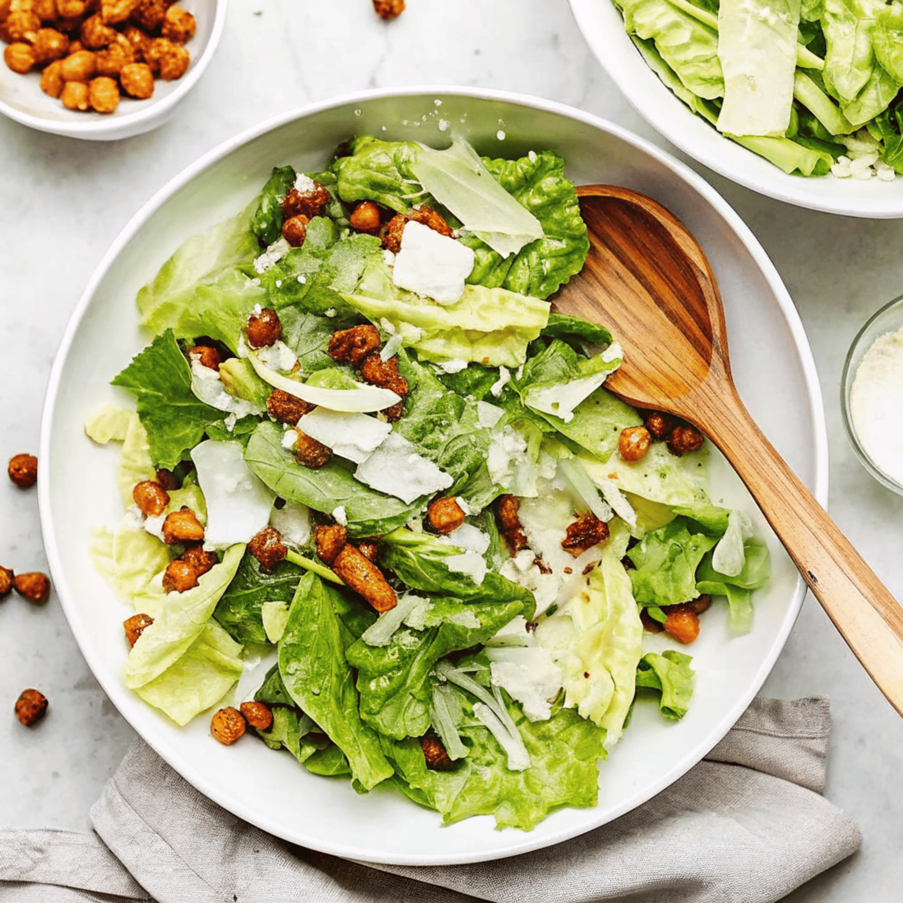 Crunchy Caesar Salad with Chickpeas and Parmesan summer salads recipes : Fresh Caesar salad with crisp romaine, roasted chickpeas, and shaved Parmesan in a white bowl.