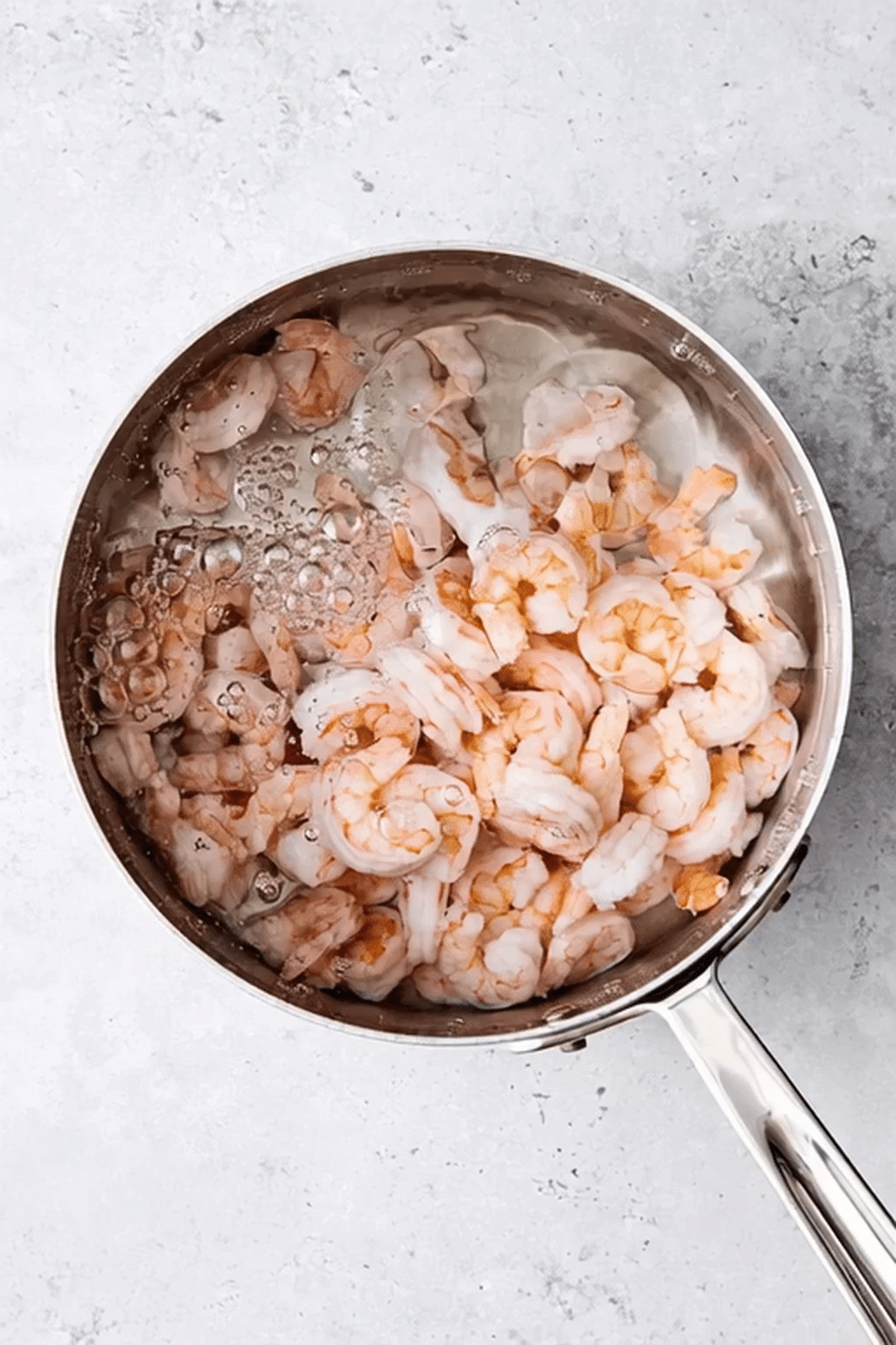 Shrimp Boiling for Fresh Salad Prep Shrimp cooking in boiling water in a stainless steel pot on a light counter