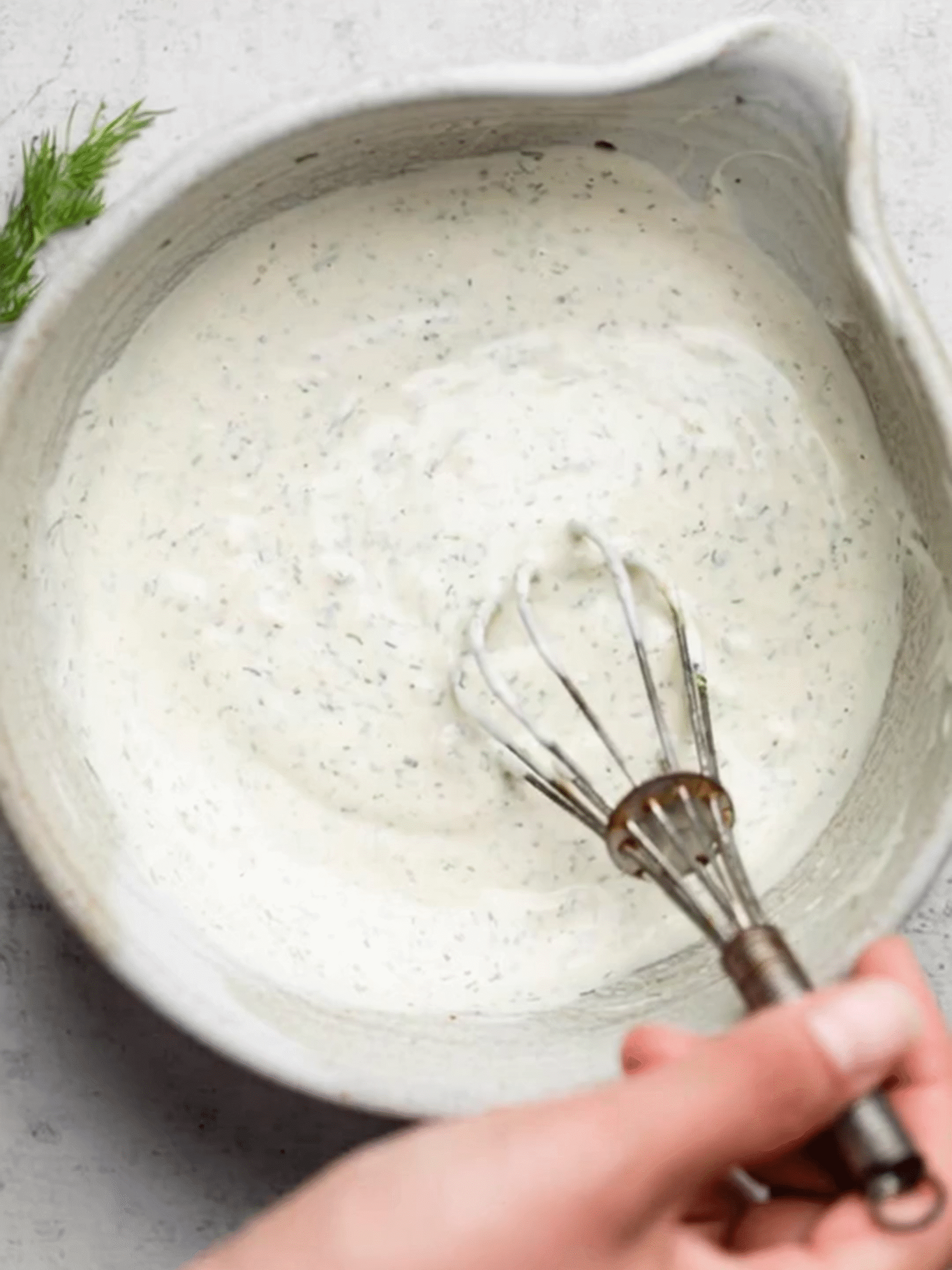Whisking the Creamy Dressing for Tuna Pasta Salad Creamy herb dressing being whisked in a white bowl for tuna pasta salad
