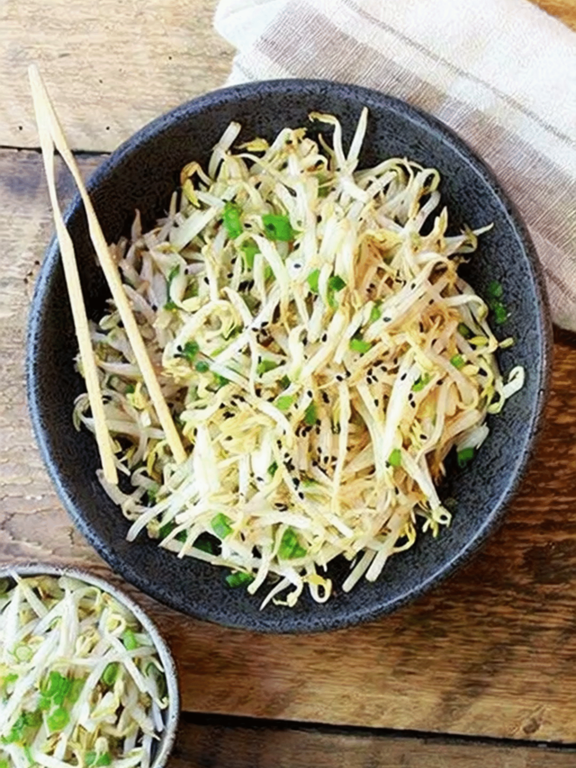 Japanese bean sprouts salad with sesame seeds and sliced green onions in a white bowl