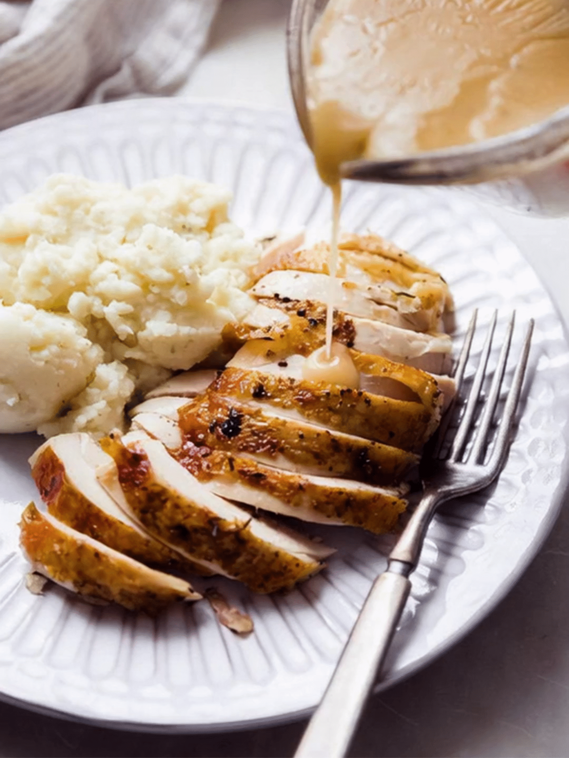 Pink Salt Seasoned Roasted Chicken Served with Gravy Sliced Pink Salt Seasoned Roasted Chicken served with mashed potatoes, topped with gravy being poured over the chicken.