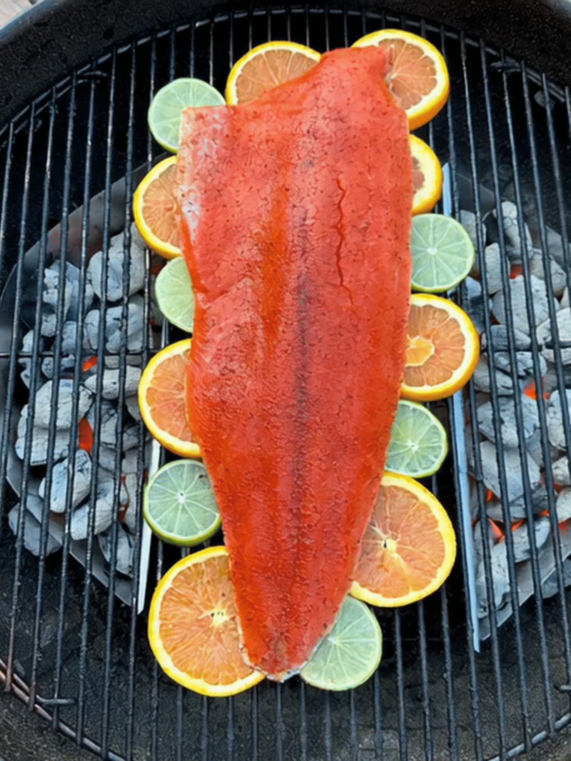 Grilled Salmon on Lime and Orange Slices Salmon fillet grilling on citrus slices over charcoal fire