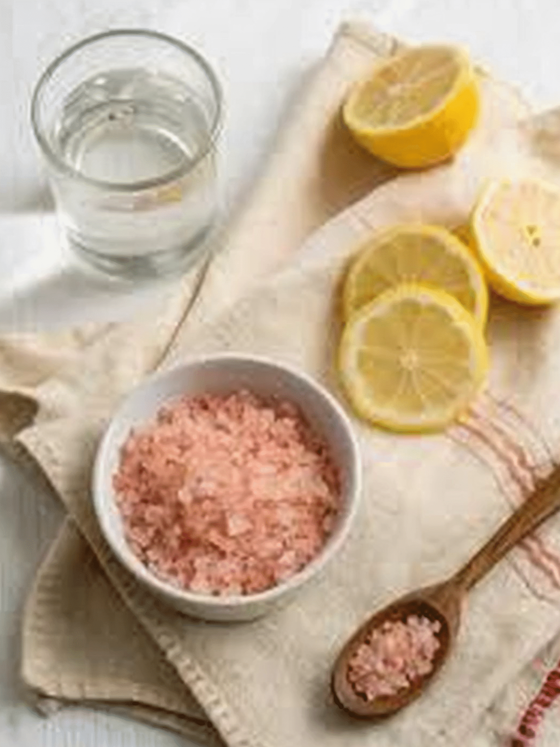 Pink Salt Weight Loss Recipe Ingredients on Cloth Ingredients for pink salt weight loss recipe including Himalayan salt, lemon slices, and a glass of water