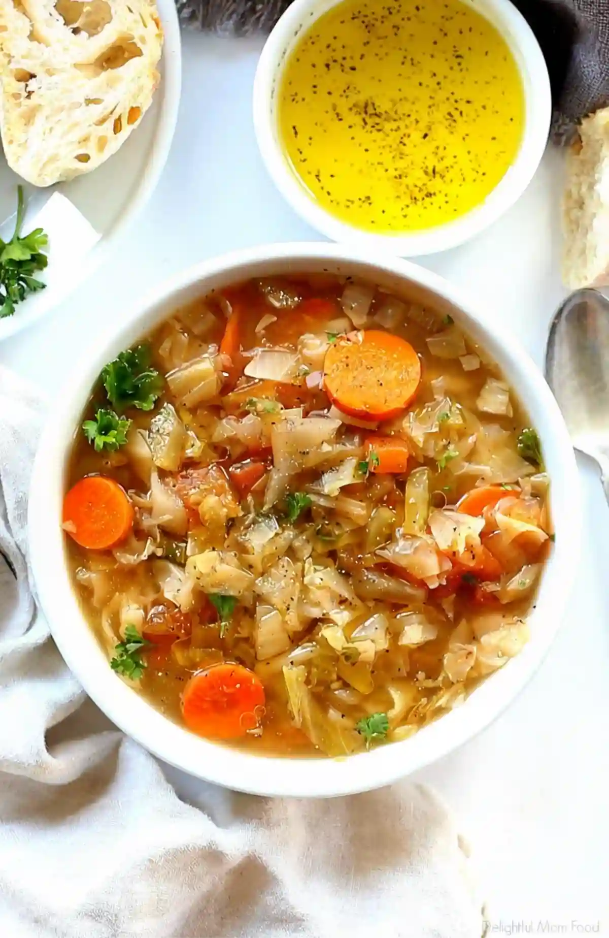 Cabbage soup diet recipe served in a white bowl with carrots cabbage herbs and light broth