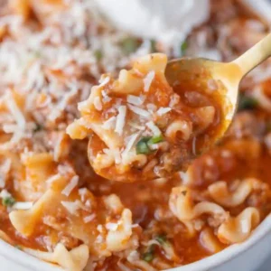 Close-up of a spoonful of High Protein Lasagna Soup with noodles, ground beef, tomato broth, and melted cheese
