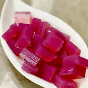 Pink gelatin cubes prepared using the Dr Oz Pink Gelatin Recipe for Weight Loss served on a white plate