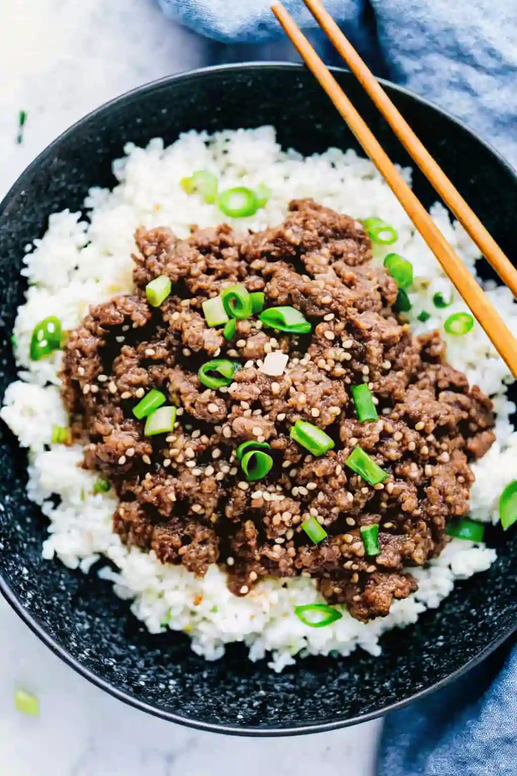 korean ground beef bowl with rice sesame seeds and green onions