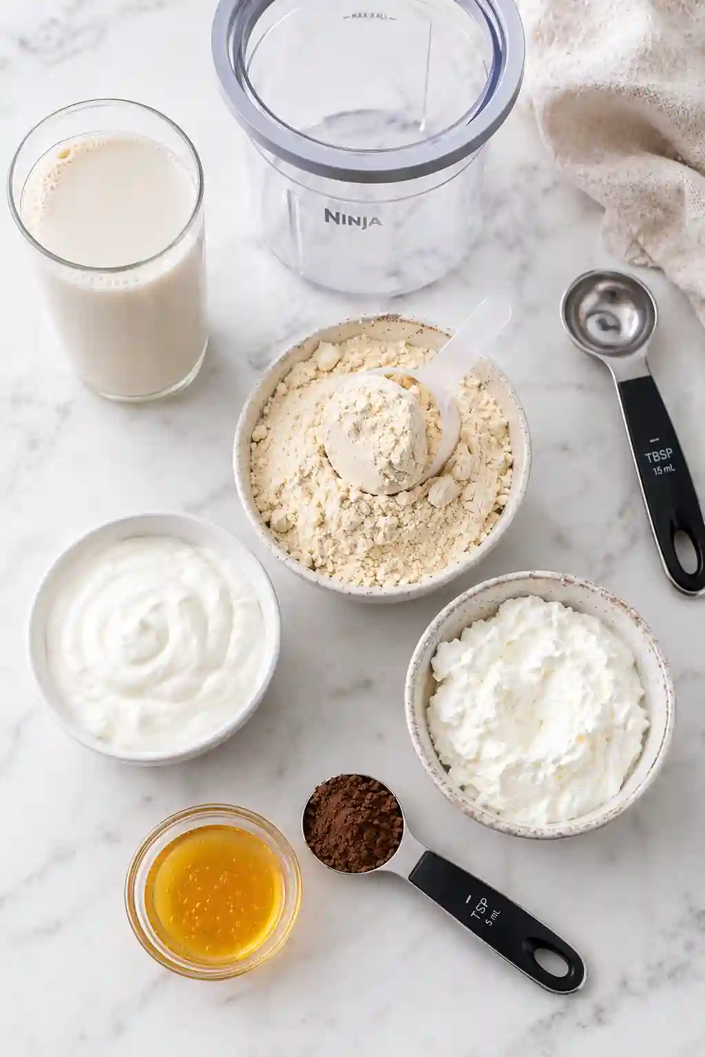 ninja creami protein ice cream recipe ingredients including protein powder milk greek yogurt cottage cheese and cocoa powder