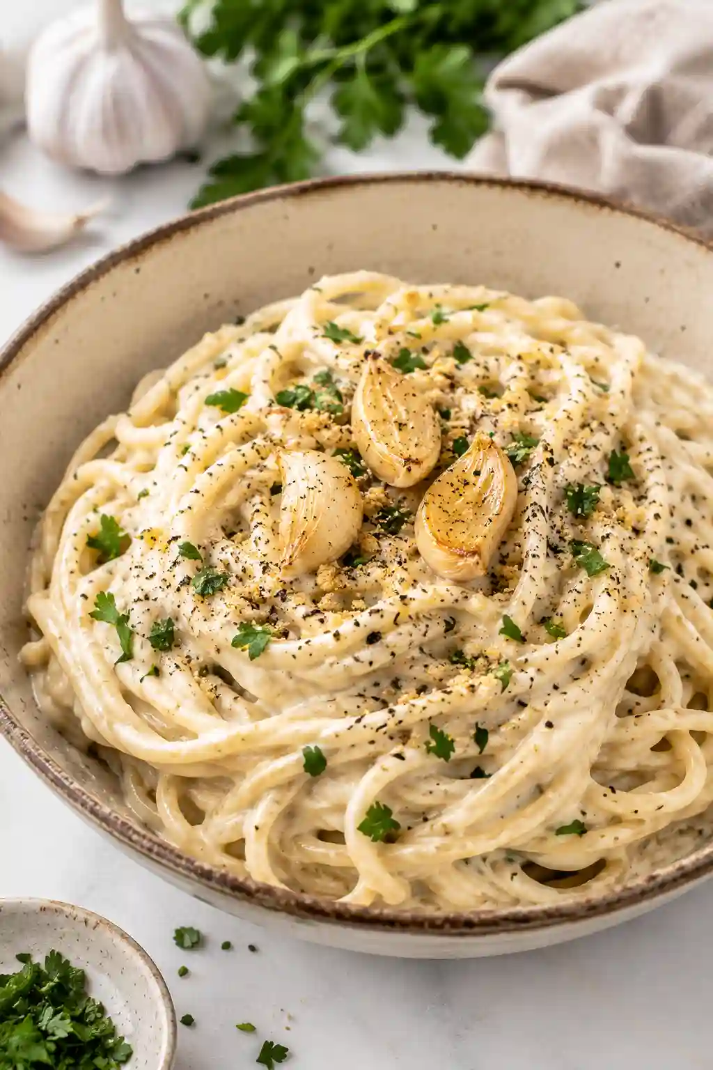 Protein Packed Vegan Alfredo Pasta Sauce made with silken tofu, chickpea spaghetti, roasted garlic, nutritional yeast, and fresh parsley