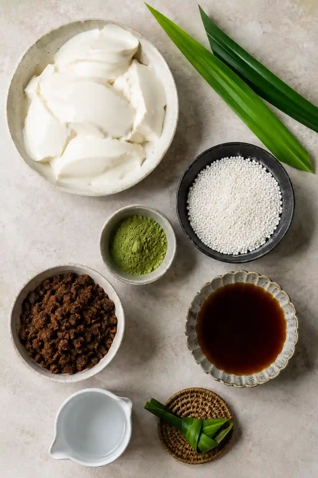 Ingredients for Matcha Taho with Brown Sugar Sago including silken tofu, matcha powder, sago pearls, brown sugar, pandan leaves, and syrup.