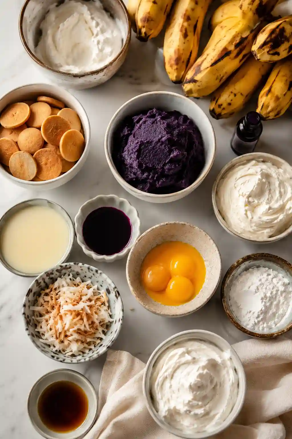 Ube Banana Pudding with Coconut Cream Ingredients Ingredients for Ube Banana Pudding with Coconut Cream including bananas, ube halaya, coconut cream, vanilla wafers, egg yolks, and whipped cream