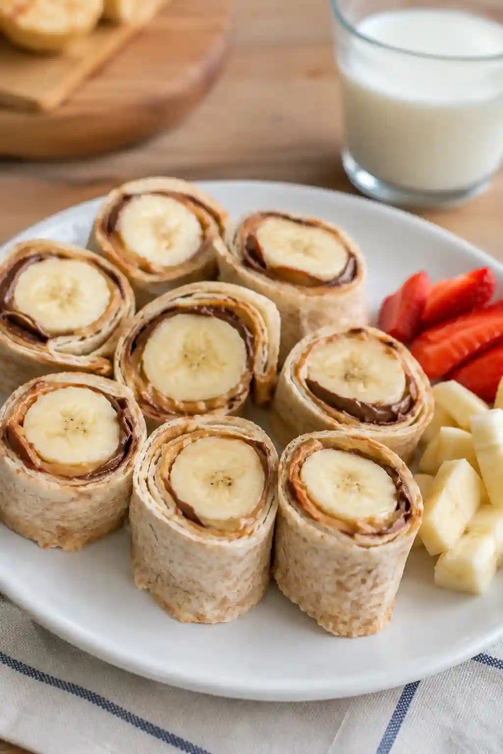 Banana Sushi Healthy Snack for Kids Banana Sushi fun healthy snack kids served with fresh strawberries, banana pieces, and a glass of milk